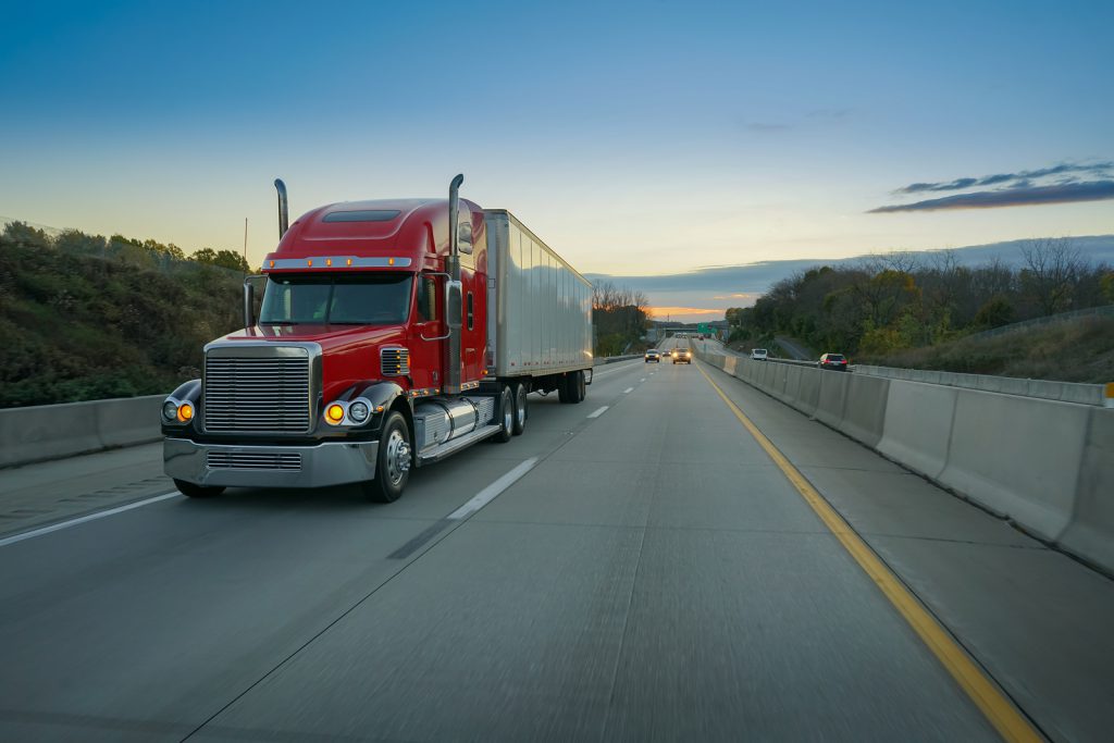 An 18-wheeler shipping truck on the highway.